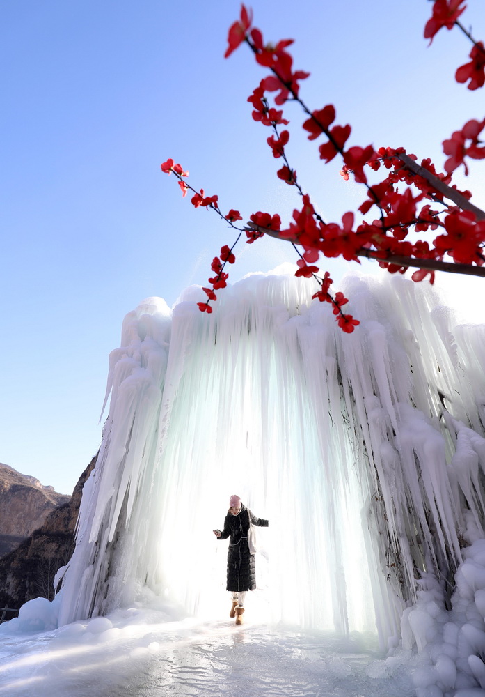 12月16日，在河北省平山縣沕沕水景區(qū)，游客在冰瀑中穿梭游玩。