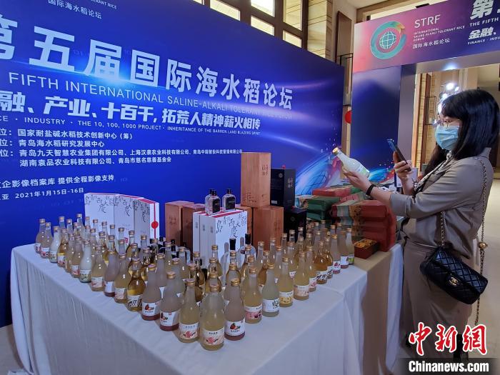 現(xiàn)場(chǎng)展出的部分海水稻產(chǎn)品。圖中玻璃瓶中裝的是海水稻米酒?！∮浾咄鯐员?攝
