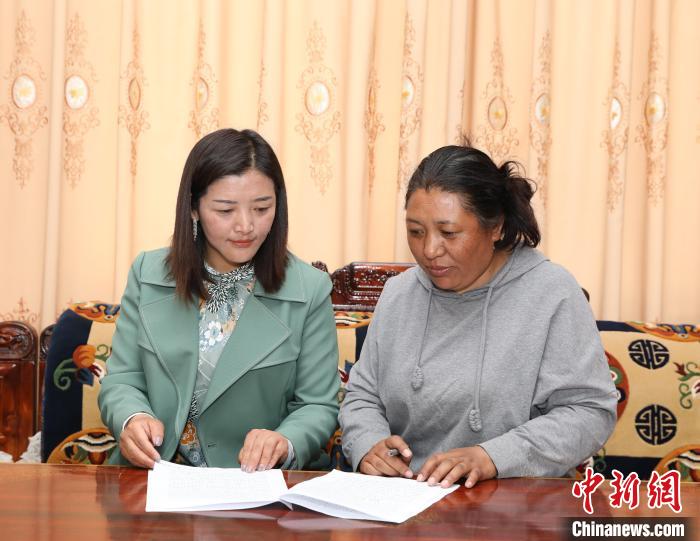 圖為扎囊養(yǎng)護段段長次旦卓瑪(左)正在與同事交流工作?！≮w延 攝